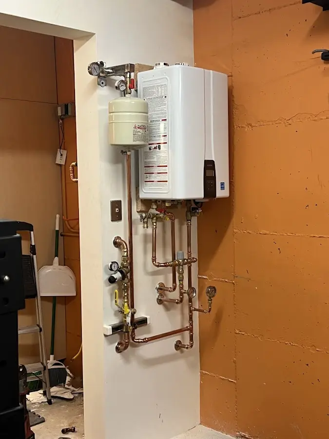 Plumbing technician inspecting water heater connections in Chanhassen